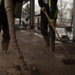 One Man Pumps the Floor Screed as One Levels It - liquid concrete