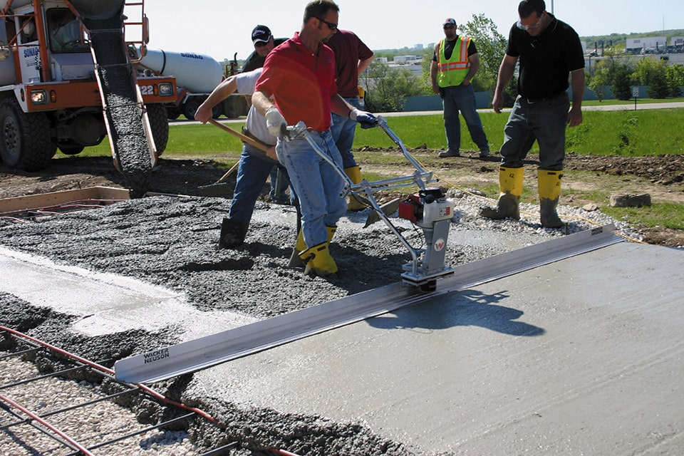 Outdoor Floor Screeding - thin floor screed miltiple men with a double handed screed tool