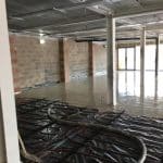 Midway Through Screeding - large pipe with entering liquid on to underfloor heating