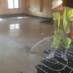 floor screed liquid, poured by one gentleman over underfloor heating system