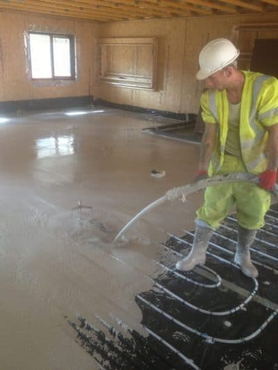 floor screed liquid, poured by one gentleman over underfloor heating system