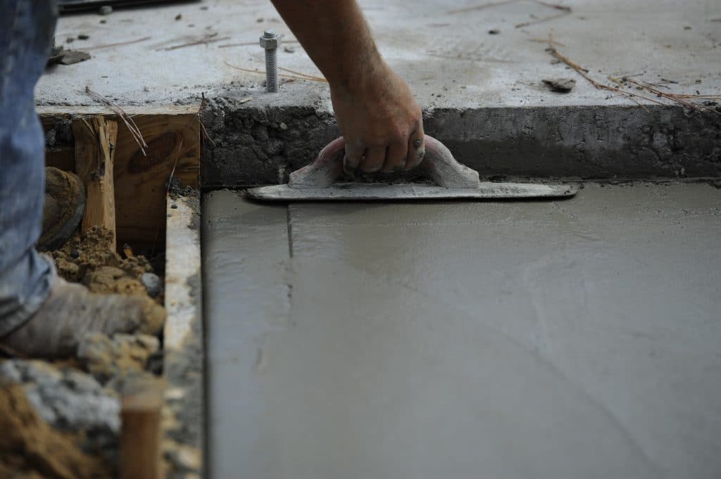 Concrete Floor screeding by hand - close up of trowel and user