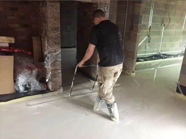 gentleman screeding indoors, newly built room, floors being leveled