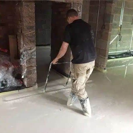 gentleman screeding indoors, newly built room, floors being leveled